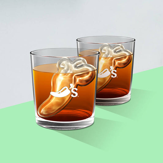 Two Aristocrat Double Old Fashioned glasses are shown filled with whiskey and ice cubes in the shape of the Chili's logo. Both glasses are deep etched with a Chili's Pepper logo.
